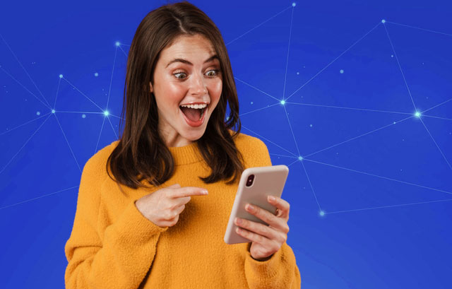 Woman smiling while looking at her smartphone